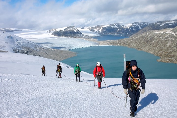 a group of people riding skis on a snowy mountain