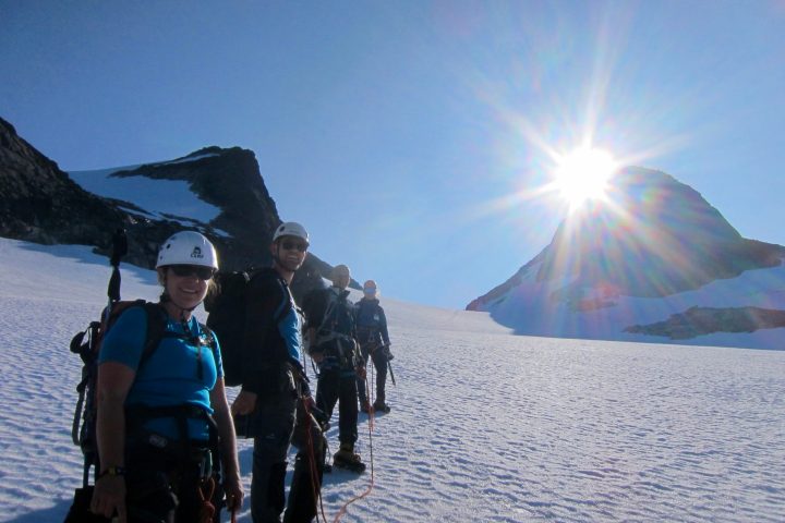 a group of people standing on top of a snow covered mountain